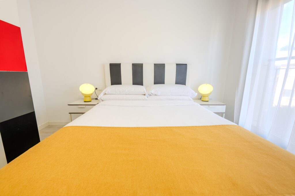 Dormitorio con cama de matrimonio de un apartamento del Castell Beach Aparthotel en Castelldefels