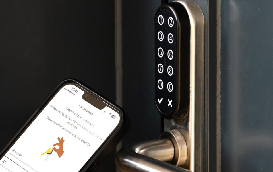 Serrure à clavier d'un appartement du Castell Beach et le code d'accès sur le téléphone du client